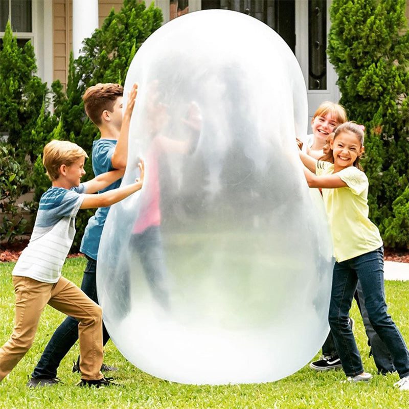 Children playing outdoors with a large transparent Giant Jelly Balloon Ball on grass